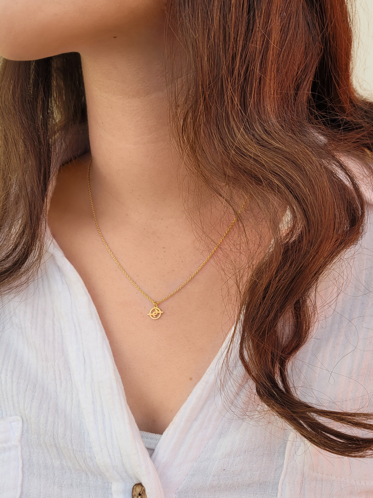 Girl with brown hair wearing 7mm gold plated solid sterling silver Joya Jewellery logo pedant on necklace