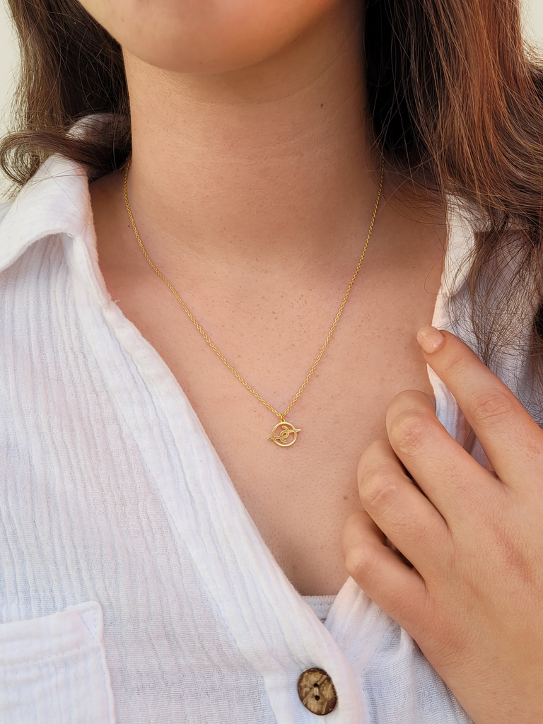 Girl with brown hair wearing 10mm gold plated solid sterling silver Joya Jewellery logo pedant on necklace