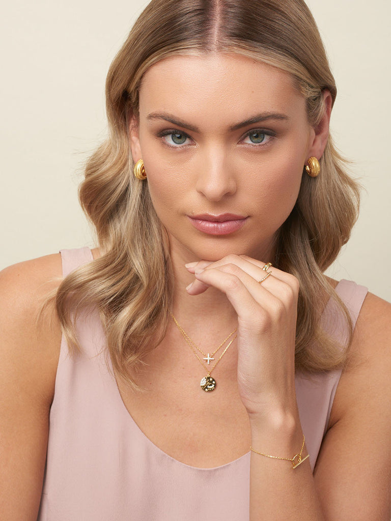 model with blonde hair and gold earrings,  displaying gold necklace with star pendant and cubic zirconia, my lucky star necklace