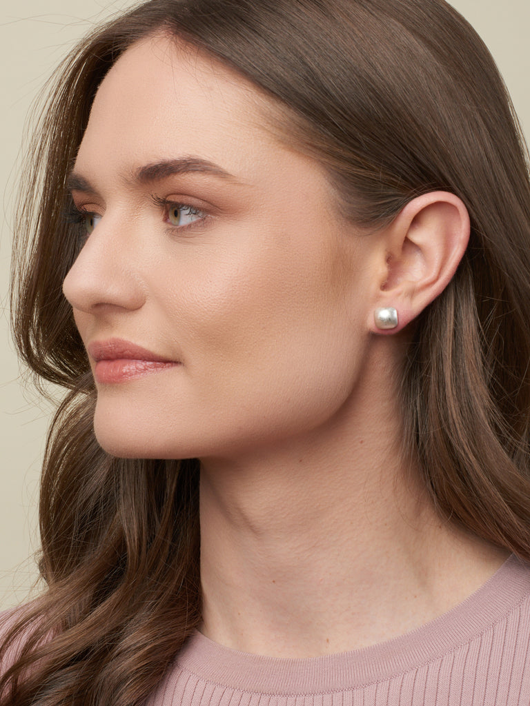 Australian model with brown hair displaying Belle studs (silver square domed studs)