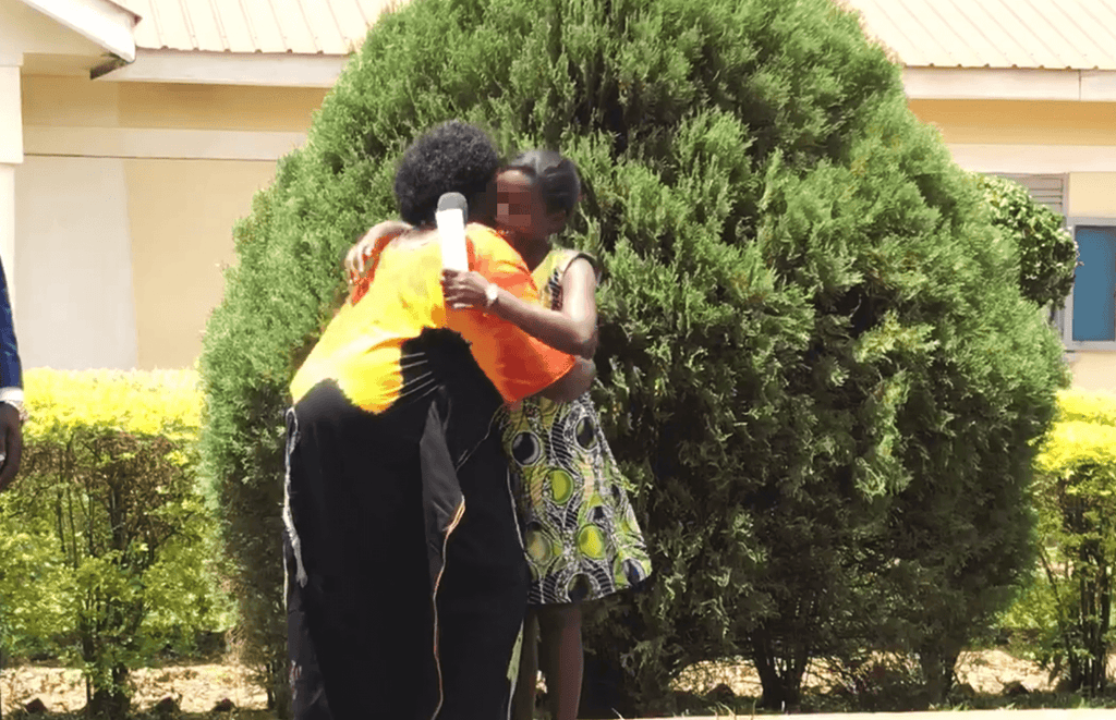 Two african women hugging at a graduation. One of the women was previously trafficked, she is free now